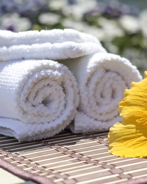 Serviettes blanches roulées et fleur d'hibiscus, prêtes pour l'accueil des clientes