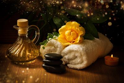 Carafe d'huile, fleur jaune et serviette roulée à la lumière des bougies