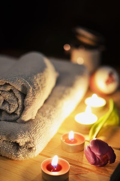 Serviette pliée et bougies allumées sur une table en bois